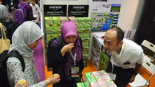 Muslim visitors to the trade show sip green tea from Japan's Harada Seicha. Malaysia's annual halal expo attracts more than 10,000 domestic and foreign exhibitors.